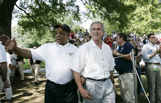Baseball legend and hall of famer Willie Mays walks with President George W. Bush as he acknowledges a standing ovation from the crowd Sunday, July 30, 2006, upon their arrival for the Tee Ball on the South Lawn game between the Thurmont Little League Civitan Club of Frederick Challengers of Thurmont, Maryland, and the Shady Spring Little League Challenger Braves of Shady Spring, West Virginia. Mays was the honorary Tee Ball commissioner for the game. Photo credit: Paul Morse, White House 
