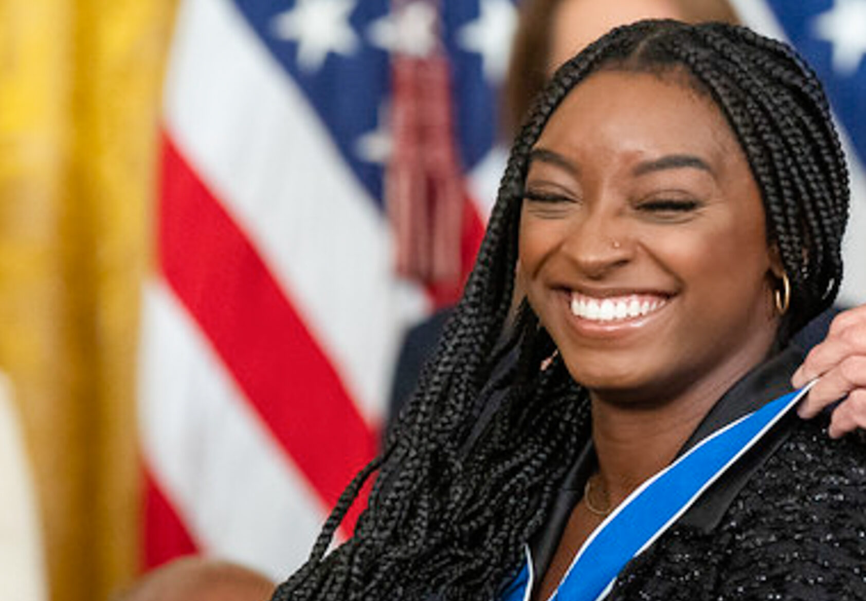 President Joe Biden presents the Medal of Freedom to gymnast Simon Biles, Thursday, July 7, 2022, in the East Room of the White House. Photo credit: Simone Biles, Adam Schultz