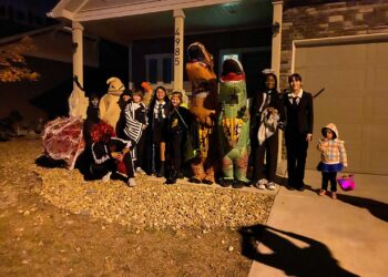 Ghost, goblins and dinosaurs, gather to trick or treat as a group in Denver, Colorado Halloween night