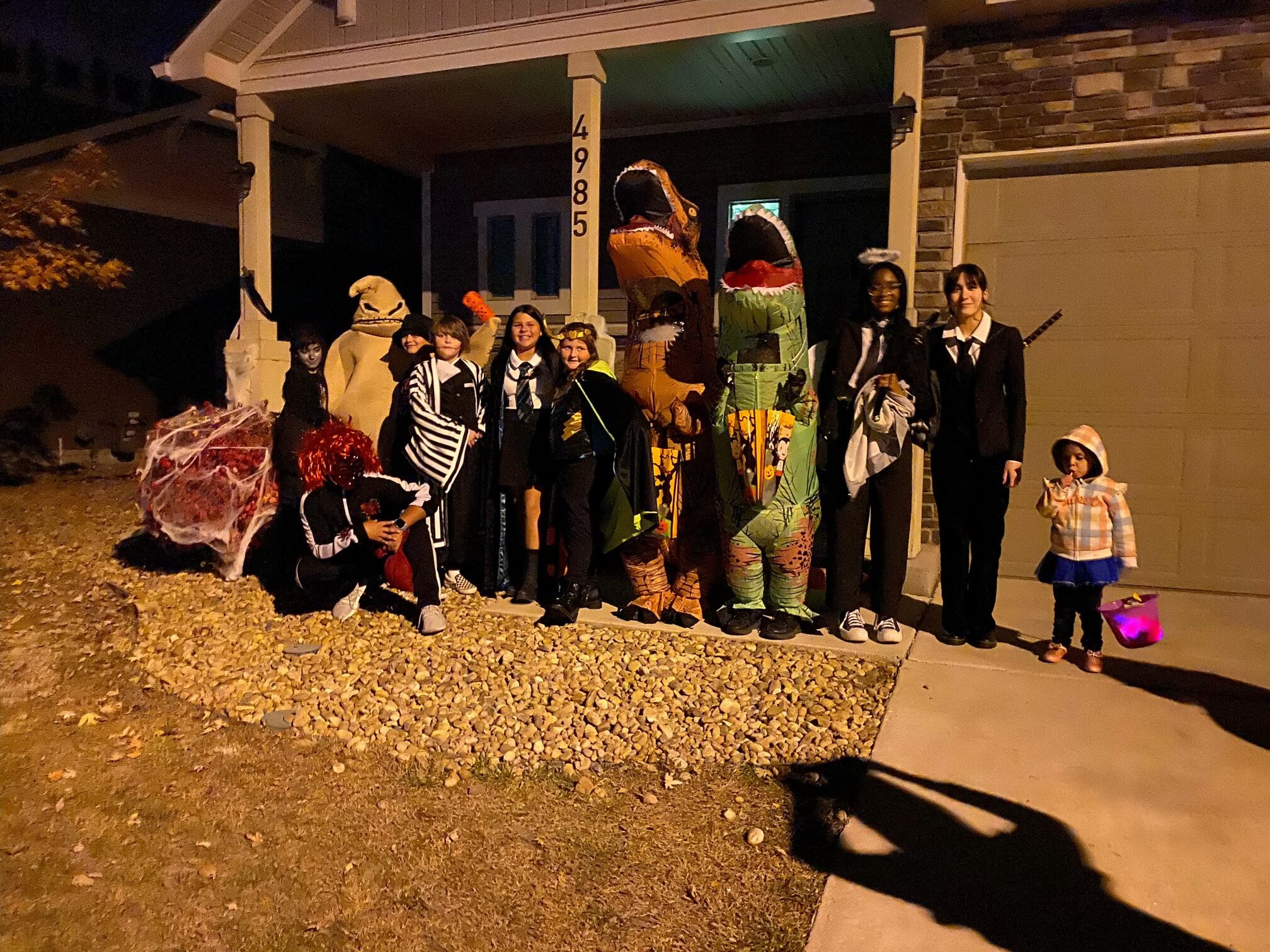 Ghost, goblins and dinosaurs, gather to trick or treat as a group in Denver, Colorado Halloween night