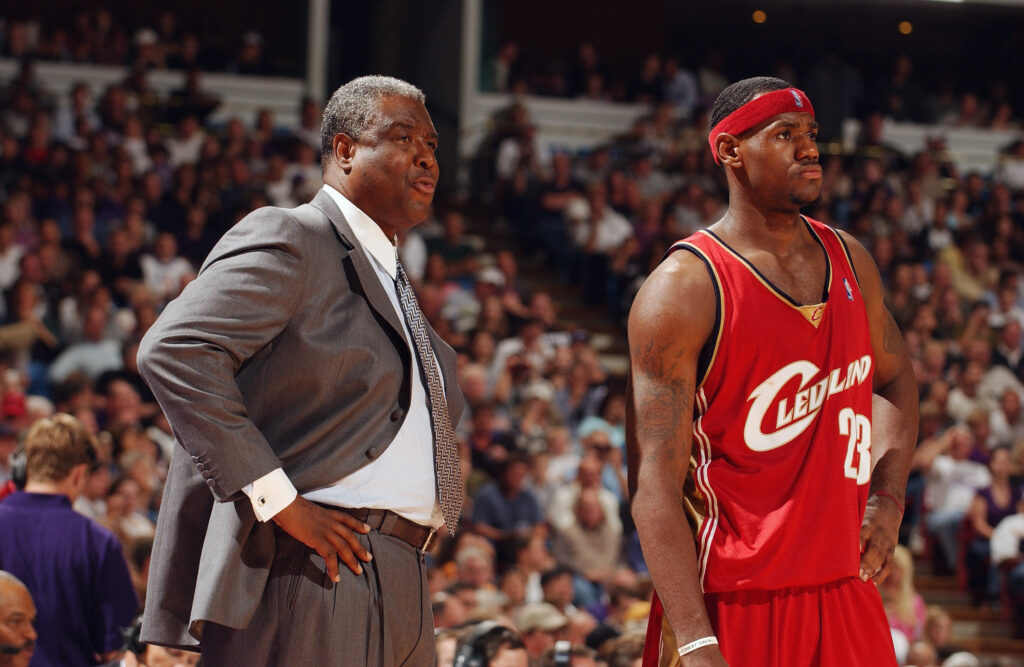 Late Cleveland Cavaliers head coach Paul Silas, left, and number 23 LeBron James, formerly of the Cavaliers, look on during an Oct. 29, 2003, away game against the Sacramento Kings at Arco Arena in Sacramento, California.  The Kings won 106-92.  Photo credit: Andrew D. Bernstein/NBAE via Getty Images