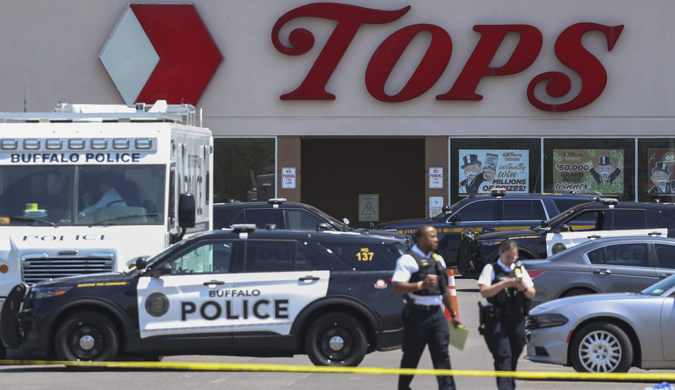 Police walk outside the Tops grocery store on Sunday, May 15, 2022, in Buffalo, New York. Payton Gendron was sentenced to life in prison Wednesday, Feb. 15, 2023, for killing 10 people at a Buffalo supermarket in an attack fueled by racist conspiracy theories he encountered online. Photo credit: Joshua Bessex, The Associated Press