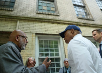Historian Eric K. Washington, left, chats with New York City Mayor Eric Adams, in the baseball cap, in front of Colored School No. 4 in the city's Chelsea neighborhood just after the building was granted landmark status. Photo credit: Michael Appleton, NYC Mayoral Photography Office