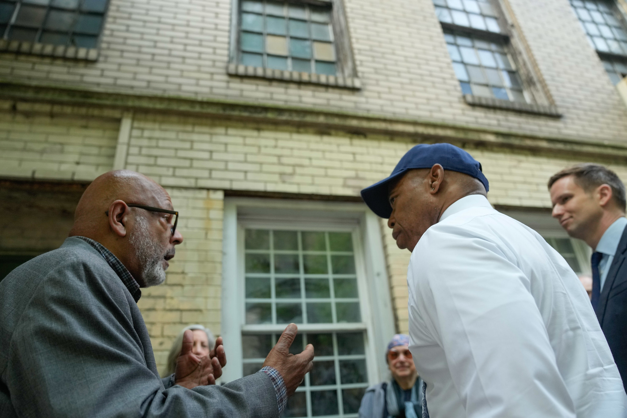Historian Eric K. Washington, left, chats with New York City Mayor Eric Adams, in the baseball cap, in front of Colored School No. 4 in the city's Chelsea neighborhood just after the building was granted landmark status. Photo credit: Michael Appleton, NYC Mayoral Photography Office