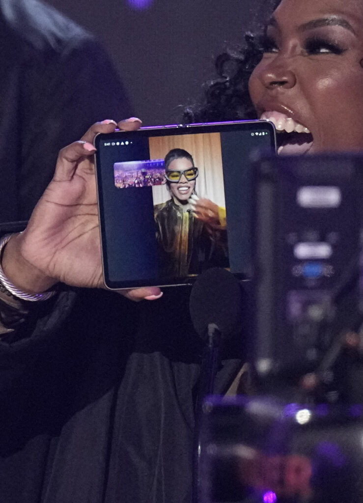 Nikki Taylor, mother of Teyana "Spike Tey" Taylor, holds a phone up as her daughter accepts the award for video director of the year remotely at the BET Awards on Sunday, June 25, 2023, at the Microsoft Theater in Los Angeles. Photo credit: Mark Terrill, The Associated Press