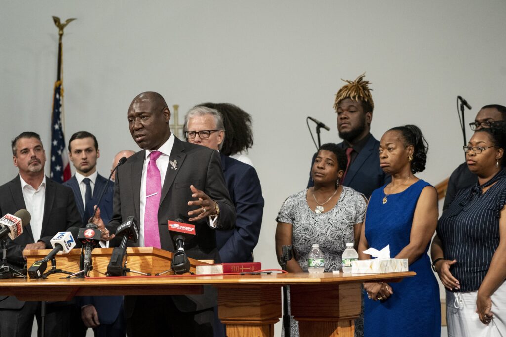 Civil rights lawyer Ben Crump, speaking, stands with relatives of the victims of the May 2022 mass shooting in Buffalo, New York, along with their lawyers. All took part in a press conference in Buffalo on Wednesday, July 12, 2023. Relatives of the victims of last year's mass shooting at Tops Friendly Market announced Wednesday they are suing the social media sites, weapons retailers and others who they say “loaded the gun” that convicted assailant Payton Gendron in the attack fueled by racist conspiracy theories he encountered online. Photo credit: Libby March, The Buffalo News via The Associated Press