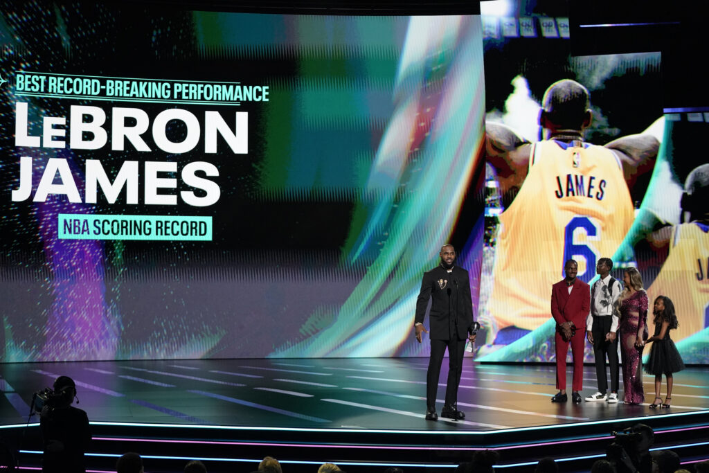NBA basketball player, LeBron James of the Los Angeles Lakers, left, accepts the ESPY Award for Best Record-Breaking Performance from family members Bronny James, Bryce James, Savannah James, and Zhuri James at the 2023 ESPY Awards on Wednesday, July 12, 2023, at the Dolby Theatre in Los Angeles. Photo credit: Mark J. Terrill, The Associated Press