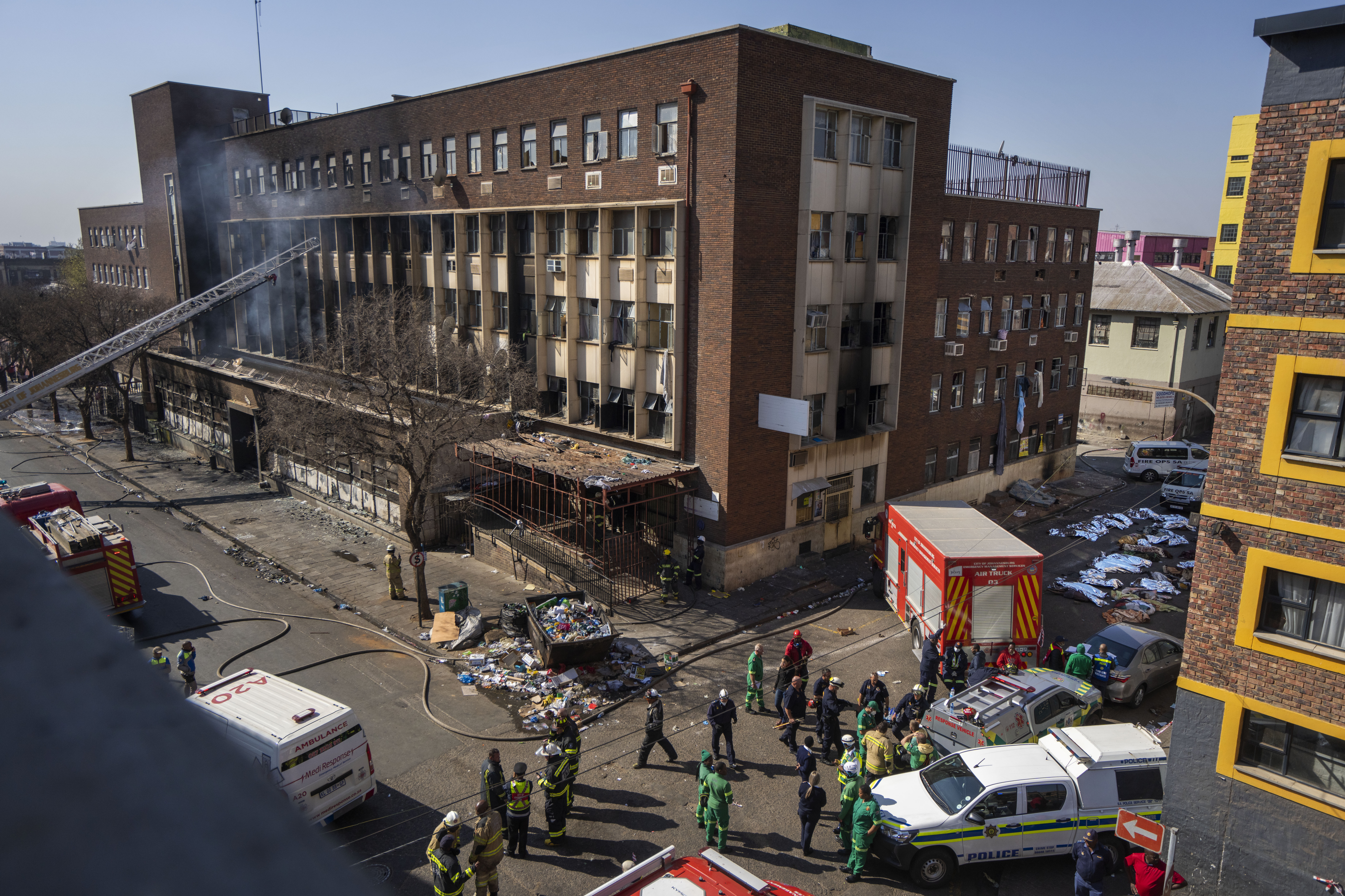 Medics and emergency workers at the scene of a deadly blaze in downtown Johannesburg, Thursday, Aug. 31, 2023. Dozens died when a fire ripped through a multi-story building in Johannesburg, South Africa's biggest city, emergency services said Thursday. Photo credit: Jerome Delay, The Associated Press