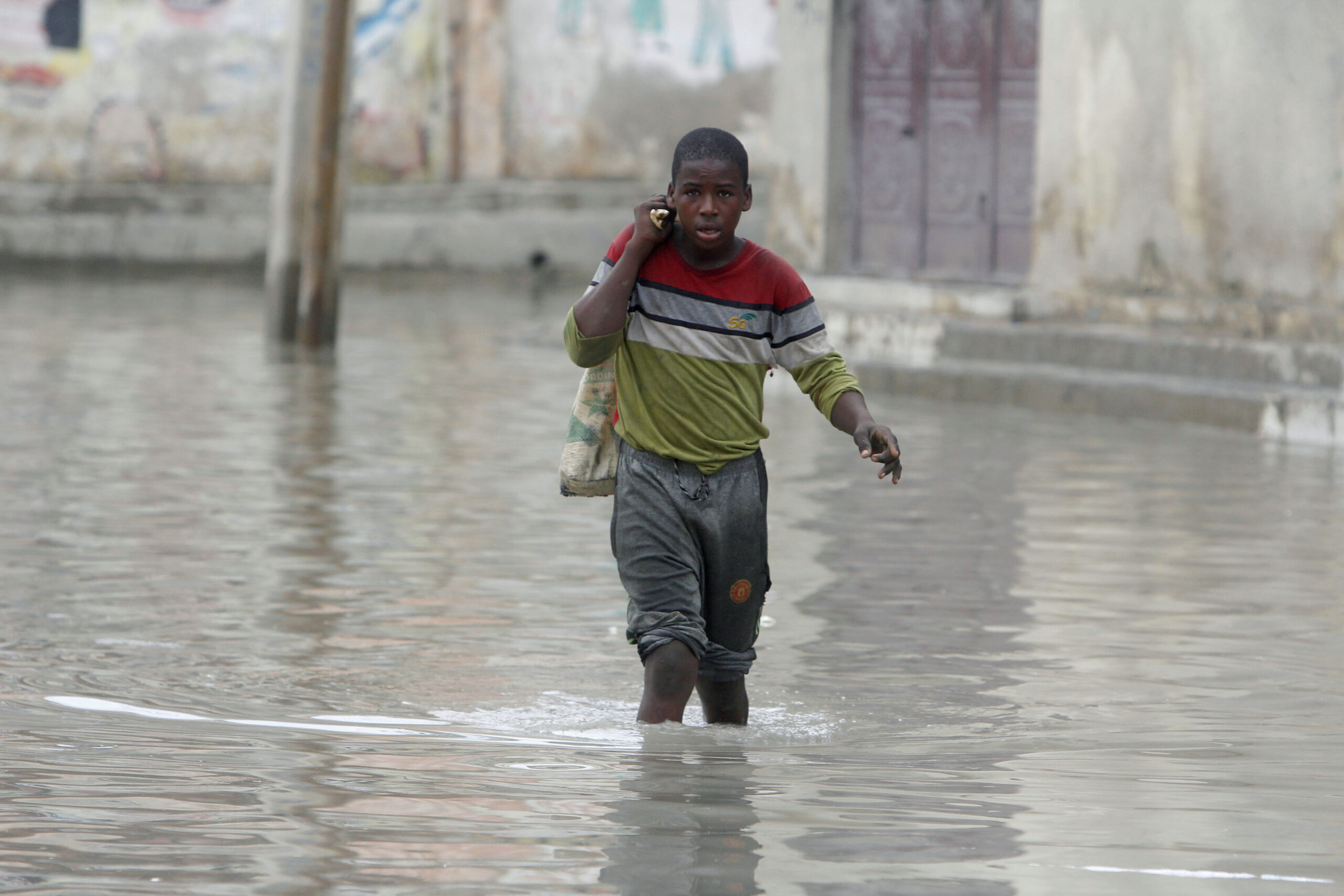 A boy makes his way through flood water caused by heavy rain in Mogadishu, Somalia, Saturday, Nov. 11, 2023. Photo credit: Farah Abdi Warsameh, The Associated Press