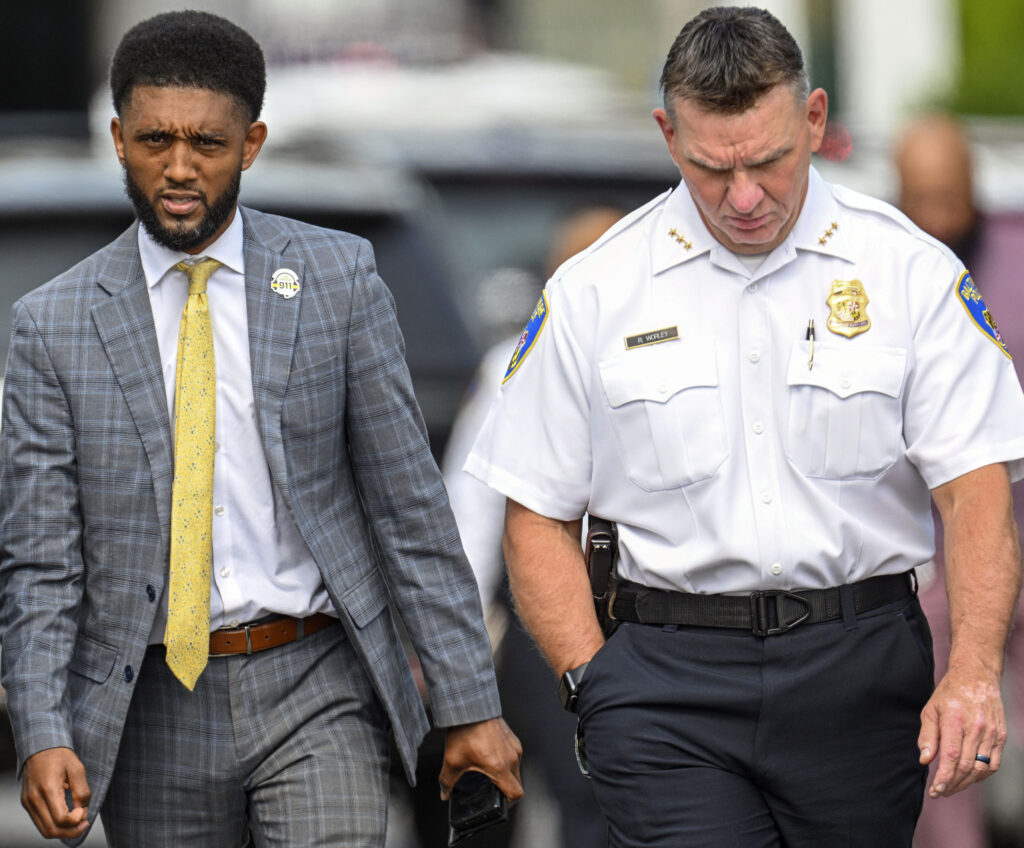Baltimore Mayor Brandon Scott, left, and Baltimore Deputy Police Commissioner Richard Worley walk to a news conference in the Shipley Hill neighborhood of Baltimore, May 11, 2023. The Baltimore Police Department has reached compliance with two sections of its court-ordered reform agreement — including a piece that governs transportation of people in custody, which landed the agency under federal oversight in the first place following the 2015 death of Freddie Gray. Photo credit: Jerry Jackson/The Baltimore Sun via The Associated Press