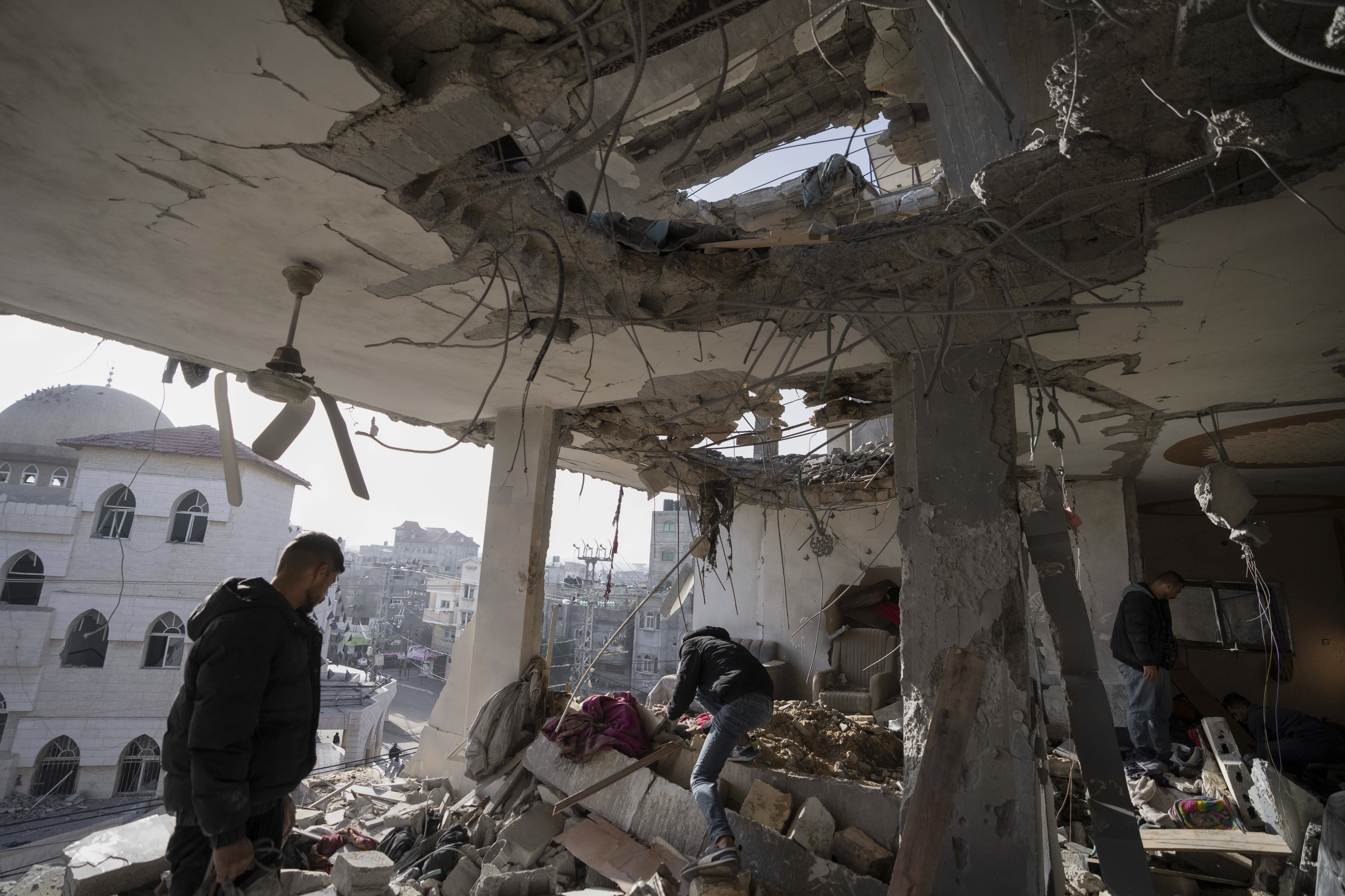 Palestinians look at a damaged residential building after an Israeli strike in Rafah, southern Gaza Strip, Wednesday, Jan. 10, 2024. Photo credit: Fatima Shbair, The Associated Press