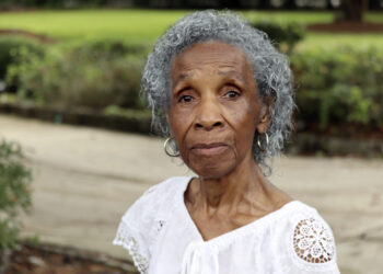 Josephine Wright poses in her yard facing a barren plot under development in Hilton Head Island, South Carolina, June 2023. Wright, who drew national attention from the likes of Tyler Perry and Snoop Dogg as she fought off developers in her final years, died Sunday, Jan. 7, 2024, at her Hilton Head home surrounded by loved ones, according to a publicist for her family. She was 94. Photo credit: James Pollard, The Associated Press