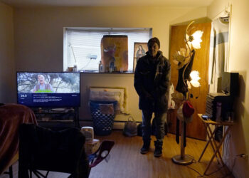 Rudolph Williams stands for a portrait in his apartment bedroom Monday, Jan. 8, 2024, in Harvey, Illinois. Williams was home in the Chicago south suburb when he realized that the doors and windows to his courtyard-style apartment had been boarded up with plywood, locking him inside. Photo credit: Charles Rex Arbogast, The Associated Press