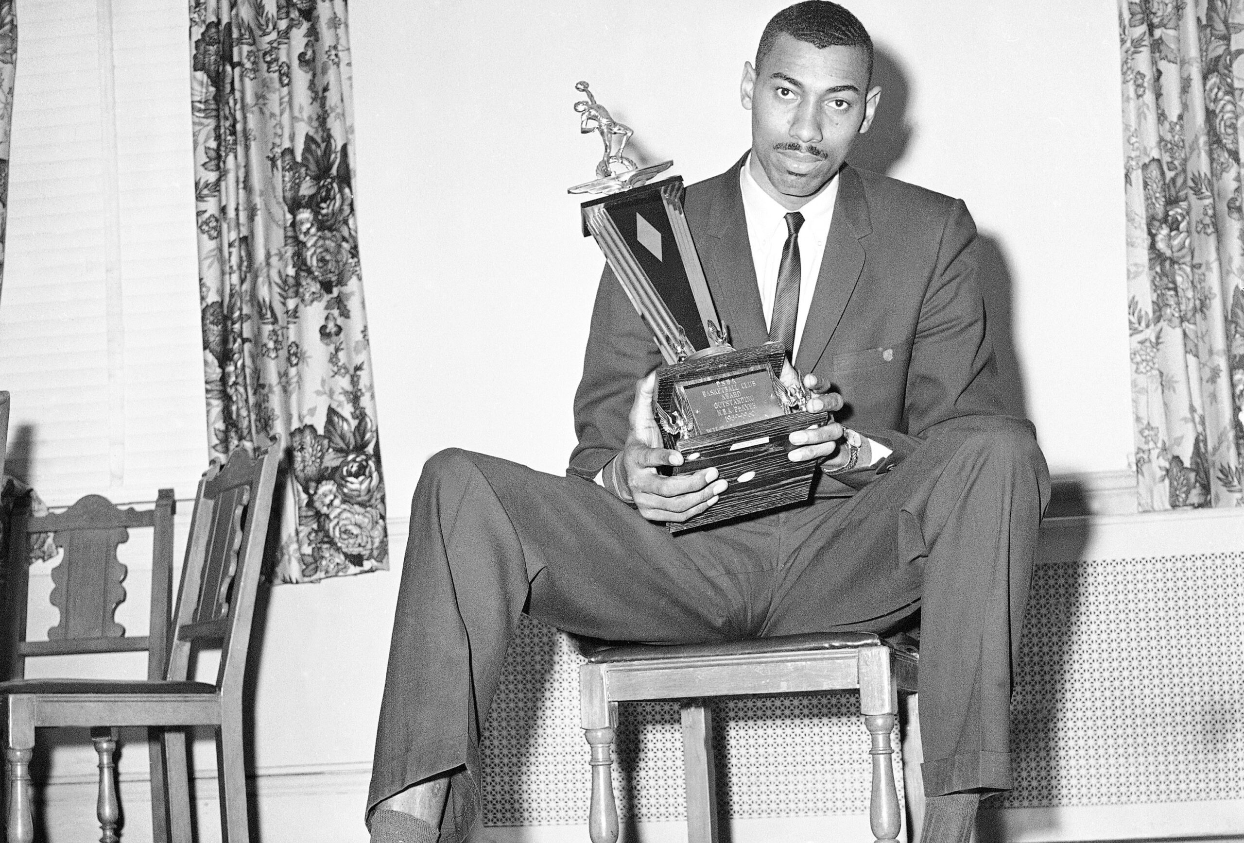 Wilt Chamberlain is shown with trophy he received from the Philadelphia Sports Writers Association Basketball Club in Philadelphia, March 28, 1960. Photo credit: Sam Myers, The Associated Press
