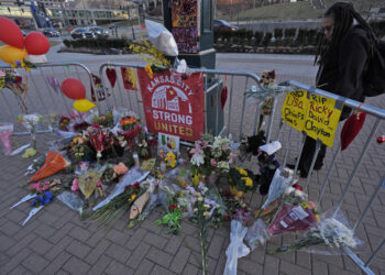A person views a memorial dedicated to the victims of last week's mass shooting in front of Union Station, Sunday, Feb. 18, 2024, in Kansas City, Missouri. Authorities say two juveniles have been charged with crimes connected to the shooting at the Kansas City Chiefs’ Super Bowl rally. Photo credit: Charlie Riedel, The Associated Press