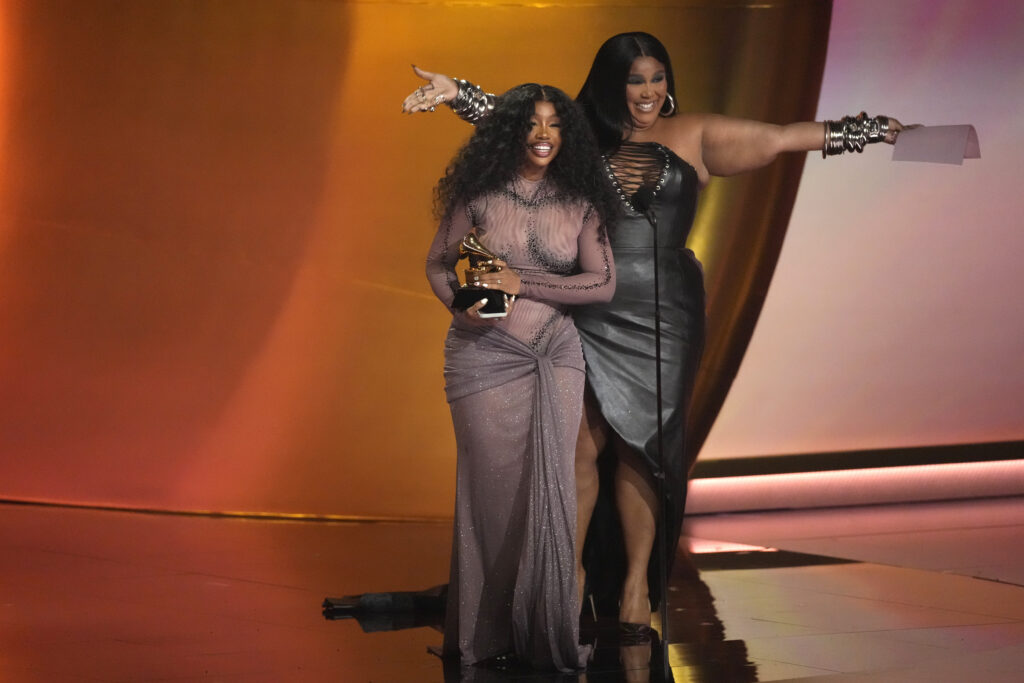 Lizzo, right, presents the award for best R&B song to SZA for "Snooze" during the 66th annual Grammy Awards on Sunday, Feb. 4, 2024, in Los Angeles. Photo credit: Chris Pizzello, The Associated Press