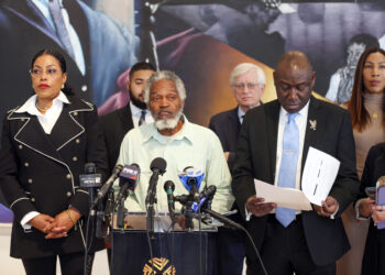 Khaleel Sultarn Sayyed, center, a member of Malcolm X's security detail, Malcolm X's daughter Ilyasah Shabazz, left, civil rights attorney Ben Crump, right, and others stand in the Audubon Ballroom, now part of The Malcolm X & Dr. Betty Shabazz Memorial and Educational Center, where the civil rights leader was shot to death 59 years ago, in New York, on Wednesday, Feb. 21, 2024. Photo credit: Ted Shaffrey, The Associated Press