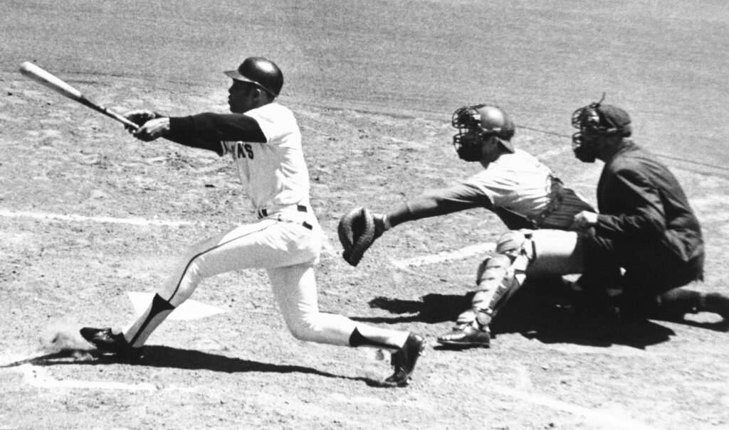 Willie Mays, center field slugger of the San Francisco Giants, connects with the 3,000th hit of his career a single to left-in second inning against Montreal on July 18, 1970, at Candlestick Park in San Francisco. Expos catcher John Bateman waits for pitch from teammate Mike Wegener. It never arrived. Umpire is Mel Steiner.   Mays received the ball immediately at ceremony on the field. Photo credit: The Associated Press