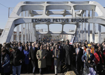 Then-Vice President Joe Biden and late U.S. Rep. John Lewis, D-Ga., lead a group across the Edmund Pettus Bridge in Selma, Alabama, March 3, 2013. Photo credit: Dave Martin, The Associated Press