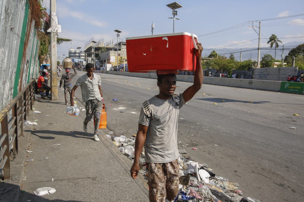 People walk along a street in Port-au-Prince, Haiti, Wednesday, March 13, 2024. Photo credit: Odelyn Joseph, The Associated Press
