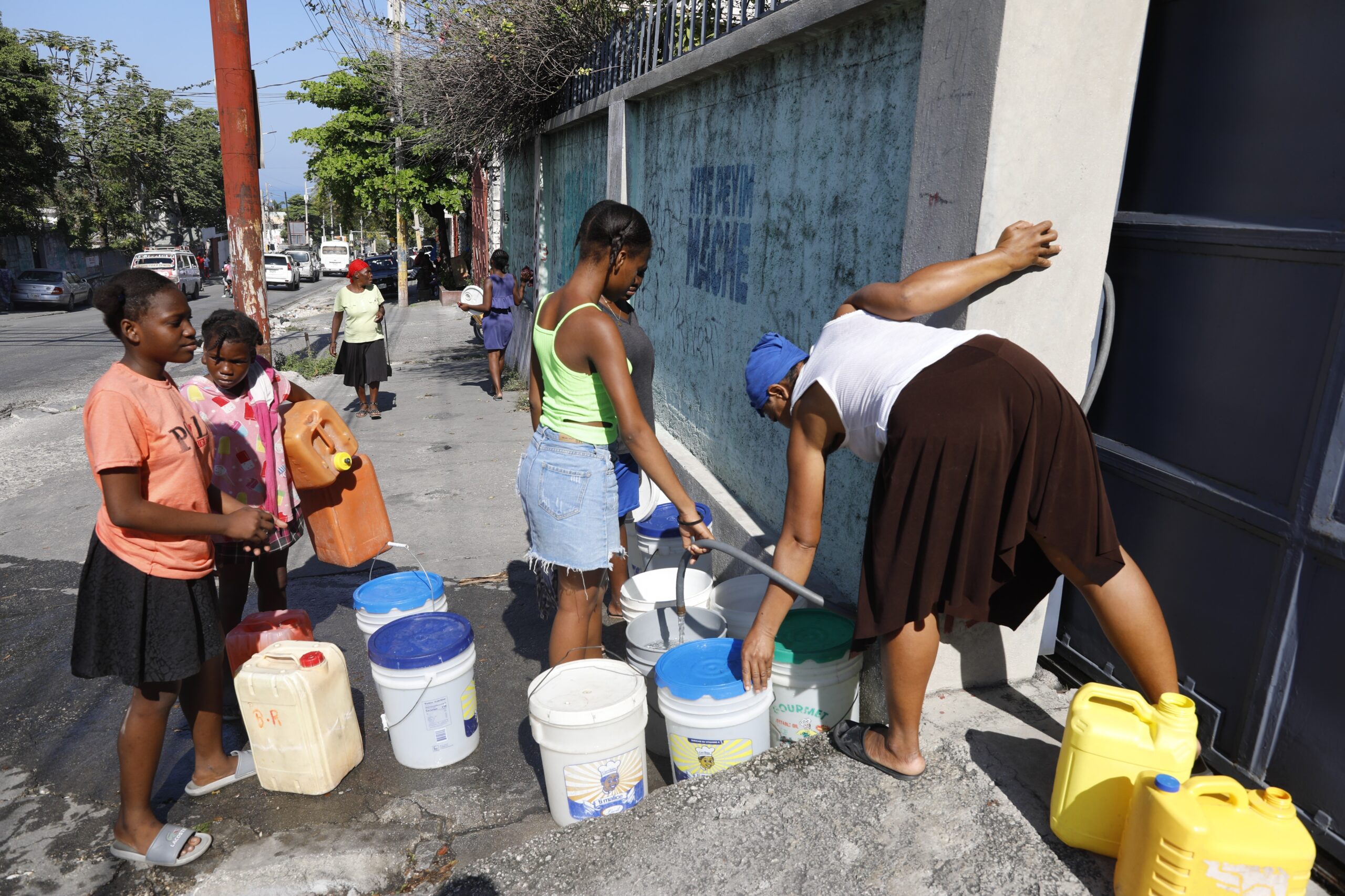 Residents fill their containers with potable water, in Port-au-Prince, Haiti, Friday, March 8, 2024. Photo credit: Odelyn Joseph, The Associated Press