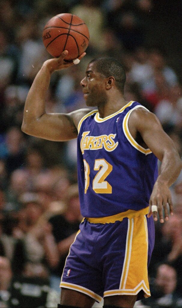 Then-Los Angeles Lakers' Earvin "Magic" Johnson holds up the ball to acknowledge the crowds' applause after making his 10,000 career assist during fourth quarter action against the Sacramento Kings in Sacramento, Calif., Thursday, March 7, 1996.  Johnson finished the game with seven assists becoming only the second player, behind Utah's John Stockton, to record 10,000 assists.  The Lakers went on to defeat the Kings 102-89. Photo credit: Rich Pedroncelli, The Associated Press