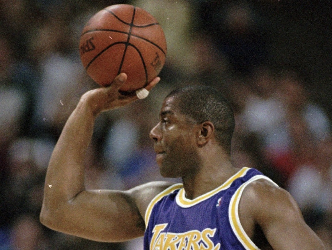 Then-Los Angeles Lakers’ Earvin “Magic” Johnson holds up the ball to acknowledge the crowds’ applause after making his 10,000 career assist during fourth quarter action against the Sacramento Kings in Sacramento, Calif., Thursday, March 7, 1996. Johnson finished the game with seven assists becoming only the second player, behind Utah’s John Stockton, to record 10,000 assists. The Lakers went on to defeat the Kings 102-89. Photo credit: Rich Pedroncelli, The Associated Press