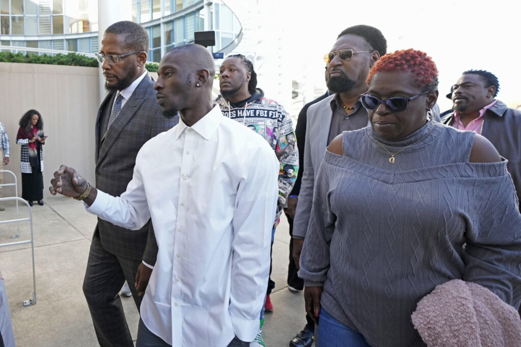 Michael Corey Jenkins, second from left, and attorney Malik Shabazz, left, are joined by supporters as they enter the Thad Cochran United States Courthouse in Jackson, Mississippi on Tuesday, March 19, 2024, for sentencing two of the six former Mississippi Rankin County law enforcement officers who committed numerous acts of racially motivated, violent torture on Jenkins and his friend, Eddie Terrell Parker, in 2023. The six former law officers pleaded guilty to a number of charges for torturing them. Photo credit: Rogelio V. Solis, The Associated Press
