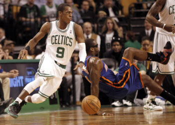 Then-Boston Celtics point guard Rajon Rondo (9) turns with the ball as New York Knicks' Amare Stoudemire falls to the floor during the second half of Boston's 91-89 win in an NBA basketball game in Boston on Friday, Feb. 3, 2012. Photo credit: Winslow Townson, The Associated Press