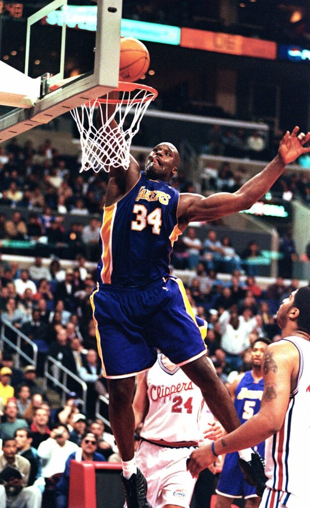 Then-Los Angeles Lakers center Shaquille O'Neal dunks the ball during the game against the Los Angeles Clippers Monday, March 6, 2000.  In this season of campaigns, Shaquille O'Neal made a convincing pitch to MVP voters — a career-high 61 points.  "It's a good feeling," O'Neal said after the Los Angeles Lakers beat the Clippers 123-103 for their 16th consecutive victory, equaling their longest winning streak of the season. Photo credit: E.J. Flynn, The Associated Press