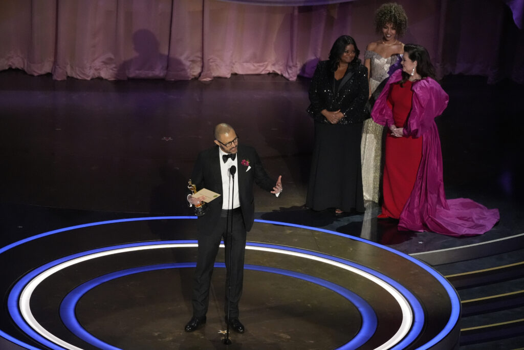 Cord Jefferson accepts the award for Best Adapted Screenplay for "American Fiction" during the Oscars on Sunday, March 10, 2024, at the Dolby Theatre in Los Angeles. Octavia Spencer, second right, and Melissa McCarthy look on from right. Photo credit: Chris Pizzello, The Associated Press