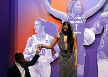 Lousiana State University's Angel Reese, right, is helped off the stage after being selected seventh overall by the Chicago Sky during the first round of the WNBA basketball draft on Monday, April 15, 2024, in New York. Photo credit: Adam Hunger, The Associated Press
