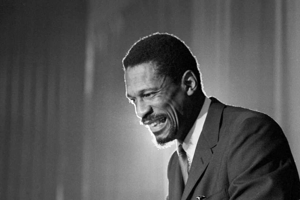 Bill Russell grins at the announcement that he was named coach of the Boston Celtics on April 18, 1966. The late Russell, then 32, a former University of San Francisco basketball  star, became the first Black head coach in National Basketball Association history. Photo credit: The Associated Press