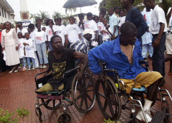 Two war victims are seen in wheelchairs at the launch of Liberia's Truth and Reconciliation Commission in the city of Monrovia, Liberia, Thursday, June 22, 2006. Then-President Ellen Johnson Sirleaf officially launched Liberia's Truth and Reconciliation Commission, saying a full accounting of atrocities committed during nearly a quarter century of conflict will set the stage for long-term peace. Now, in 2024, Liberian lawmakers are pushing forward with a proposal to set up a war crimes court. Photo credit: Pewee Flomoku, The Associated Press