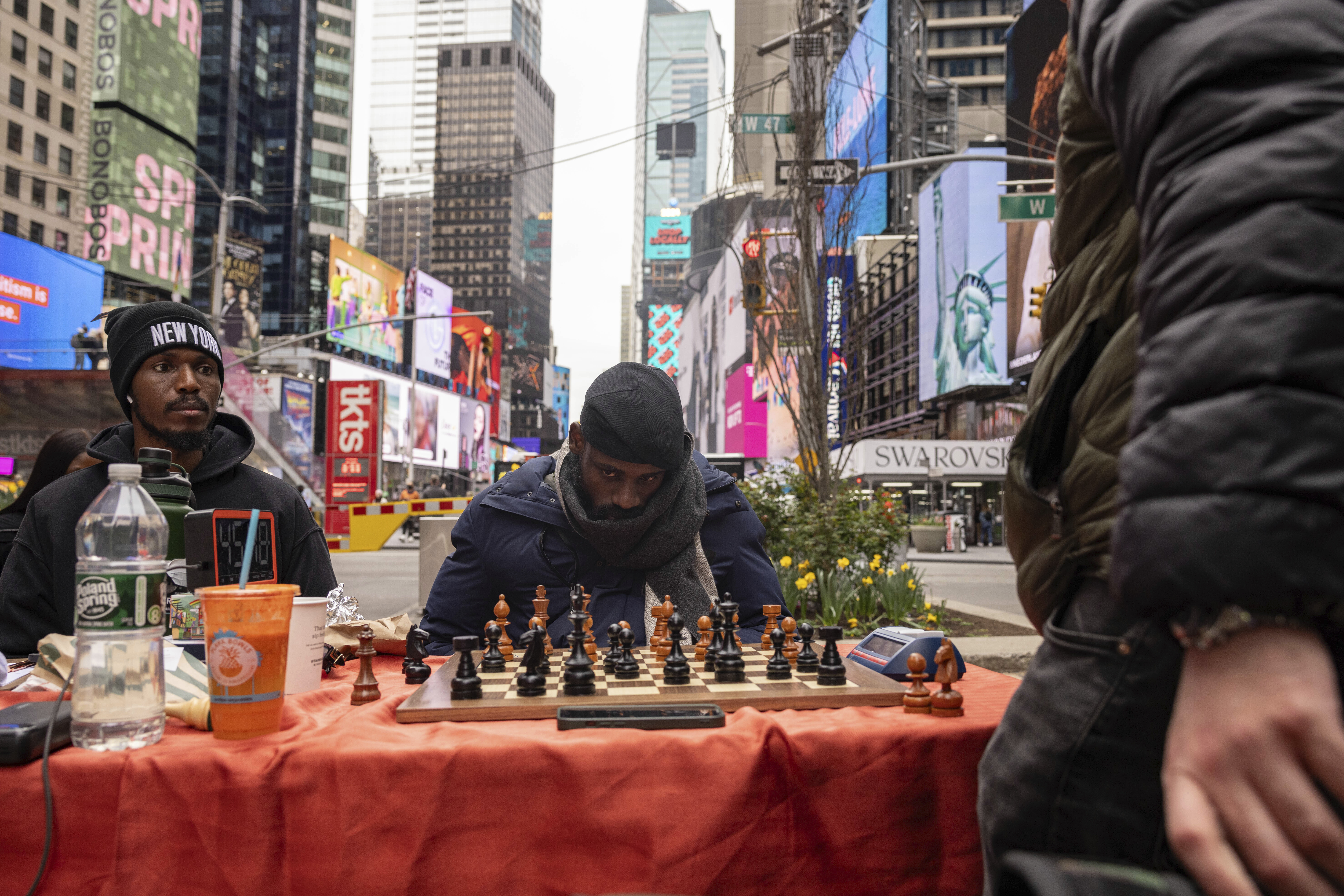 Tunde Onakoya, 29, a Nigerian chess champion and child education advocate, plays a chess game in Times Square, Friday, April 19, 2024, in New York. Photo credit: Yuki Iwamura, The Associated Press