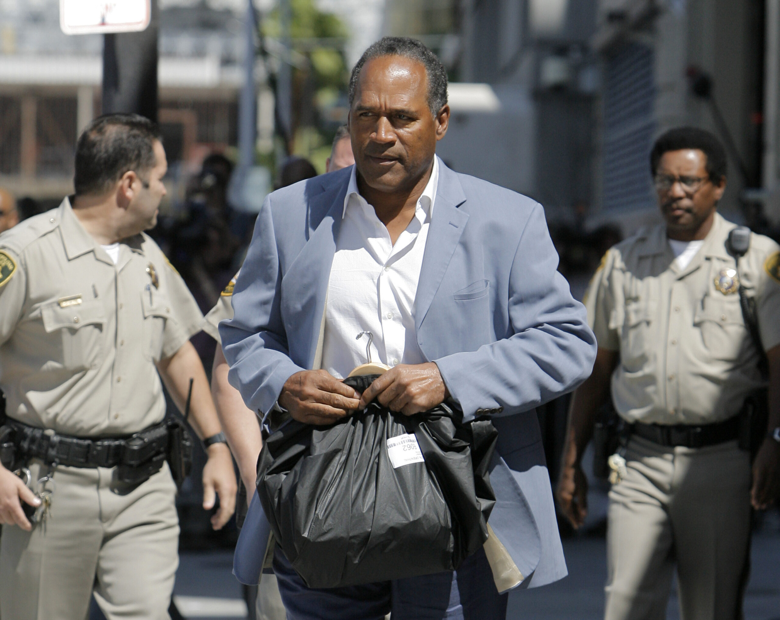 Reports indicate that O.J. Simpson has died at the age of 76 of cancer. Here, Simpson is seen as he leaves the Clark County Detention Center after he was granted bail in Las Vegas, Wednesday, Sept. 19, 2007. Simpson was released from jail Wednesday after posting $125,000 bail in connection with the armed robbery of sports memorabilia collectors at a Las Vegas hotel. Simpson, wearing a light blue sport coat and dark blue pants, carried a black bag as he strolled to a gray sedan with his lawyer and drove away from the Clark County Detention Center. Photo credit: Jae C. Hong, The Associated Press