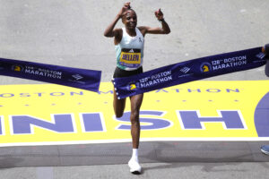 Hellen Obiri of Kenya raises her arms as she wins the women's division at the Boston Marathon on Monday, April 15, 2024, in Boston. Photo credit: Charles Krupa, The Associated Press