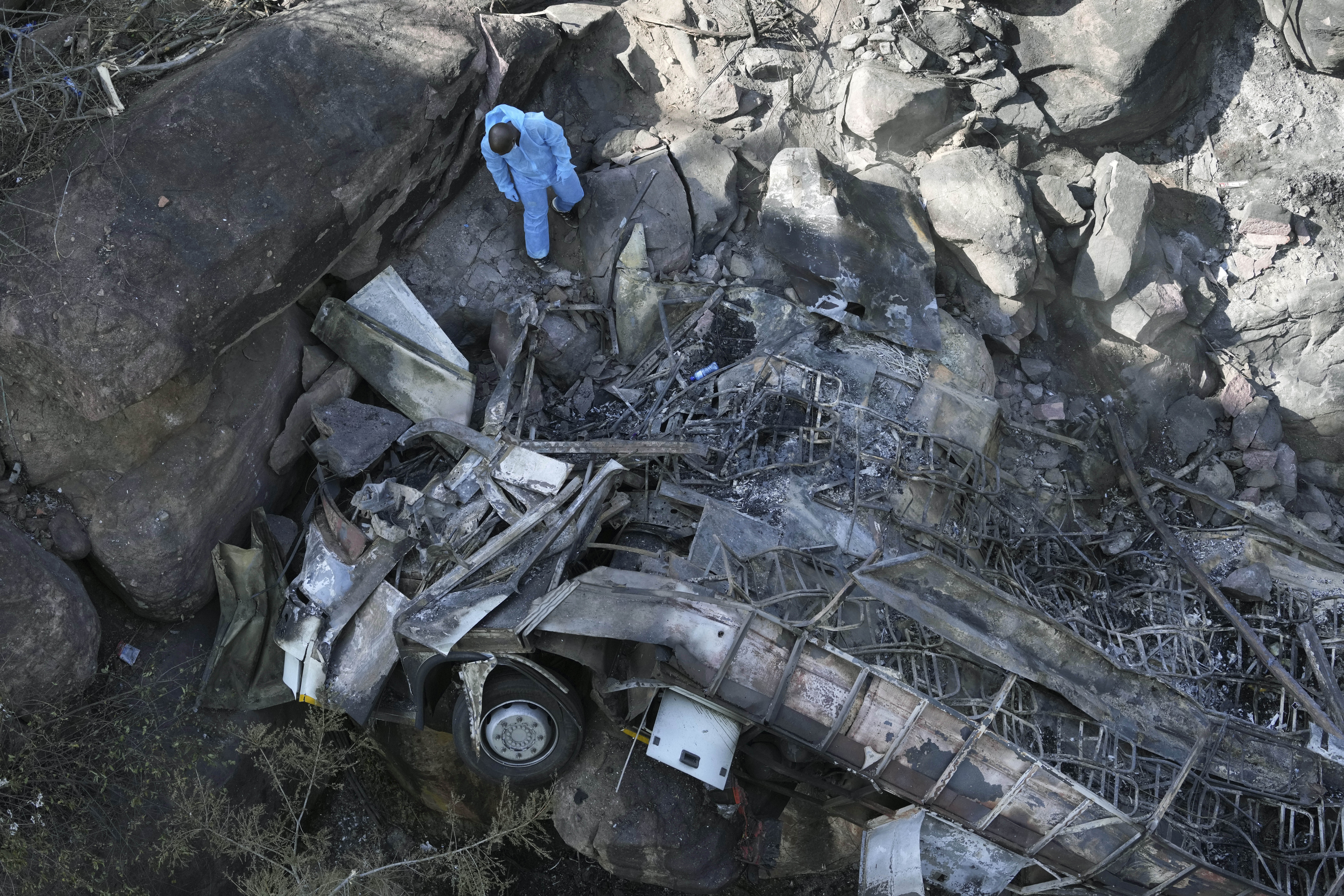 The wreckage of a bus lays in a ravine a day after it plunged off a bridge on the Mmamatlakala mountain pass between Mokopane and Marken, around 300km (190 miles) north of Johannesburg, South Africa, Friday, March 29, 2024. The bus carrying worshippers on a long-distance trip from Botswana to an Easter weekend church gathering in South Africa plunged off a bridge on a mountain pass Thursday and burst into flames as it hit the rocky ground below, killing at least 45 people, authorities said. The only survivor was an 8-year-old child who was receiving medical attention for serious injuries. Photo credit: Themba Hadebe, The Associated Press