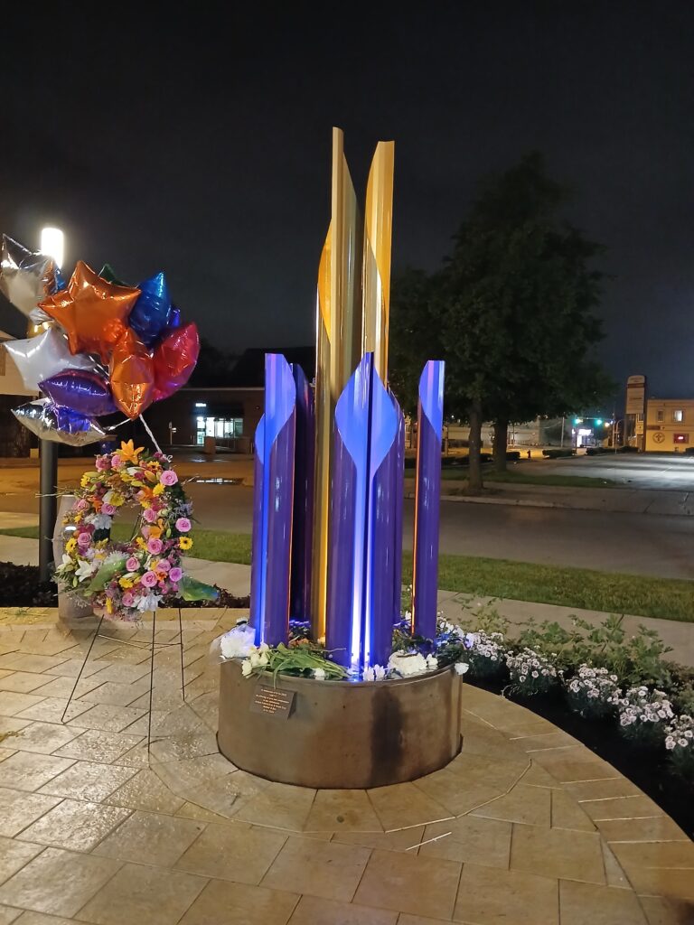 An evening view of the sculpture titled Unity that was unveiled Tuesday, May 14, 2024, as Buffalo, New York, marked the second anniversary of a racially motivated mass shooting that killed 10 shoppers and employees at a Tops supermarket. The sculpture is part of the newly constructed 5/14 Tops Honor Space in front of the store. Photo credit: Nanette Massey, NABJ Black News & Views