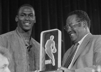 The Chicago Bulls' Michael Jordan, left, receives the NBA's Rookie of the Year trophy from an unidentified NBA official during the NBA award ceremony in San Francisco, June 24, 1985. Photo credit: Paul Sakuma, The Associated Press