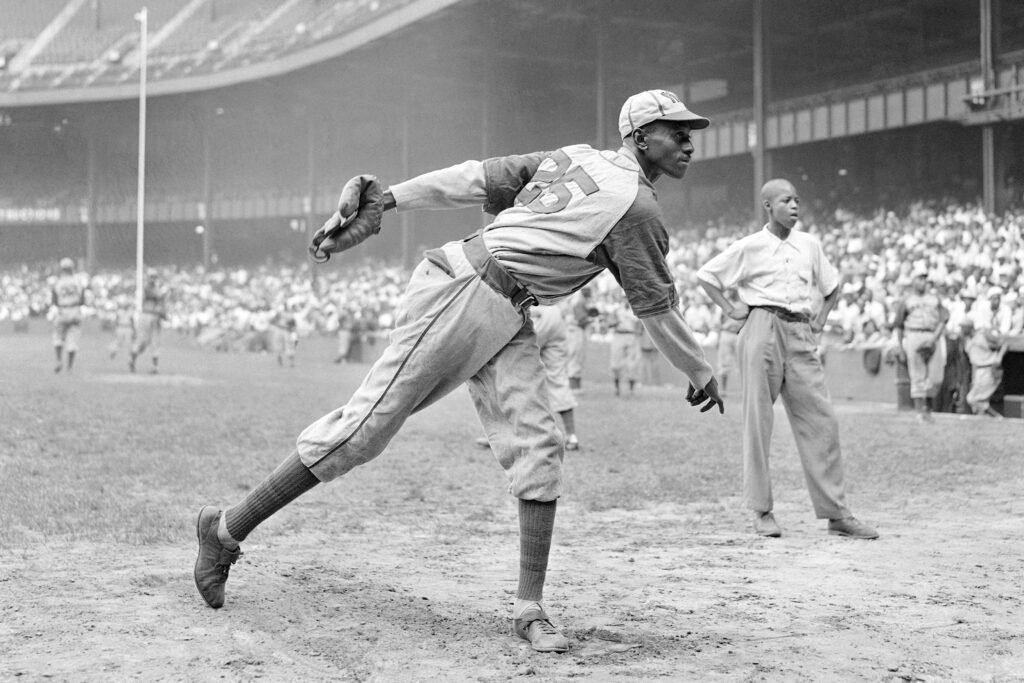 In this Aug. 2, 1942, file photo, Kansas City Monarchs pitcher Leroy Satchel Paige warms up at New York's Yankee Stadium before a Negro League game between the Monarchs and the New York Cuban Stars. Major League Baseball said Tuesday, May 28, 2024, that it has incorporated records for more than 2,300 Negro Leagues players following a three-year research project. Paige’s 1.01 ERA for the 1944 Kansas City Monarchs of the Negro American League ranks third since ERA became an official stat in the National League in 1912 and American League in 1913. Paige was also credited with 28 Negro Leagues wins, raising his career total to 125.  Photo credit: Matty Zimmerman, The Associated Press