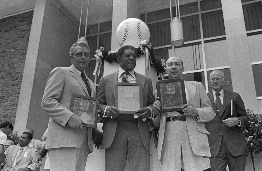 Willie Mays, center, is joined by Bill Giles, left, and Robert Wilson as the three display their Hall of Fame placques on Sunday, August 5, 1979at the National Baseball Hall of Fame in Cooperstown, New York.   Mays was the only living player inducted that year as Giles accepted for his father Warren Giles, former National League president and Wilson accepted for his father, Hack Wilson, a former player. Photo credit: Ray Howard, The Associated Press