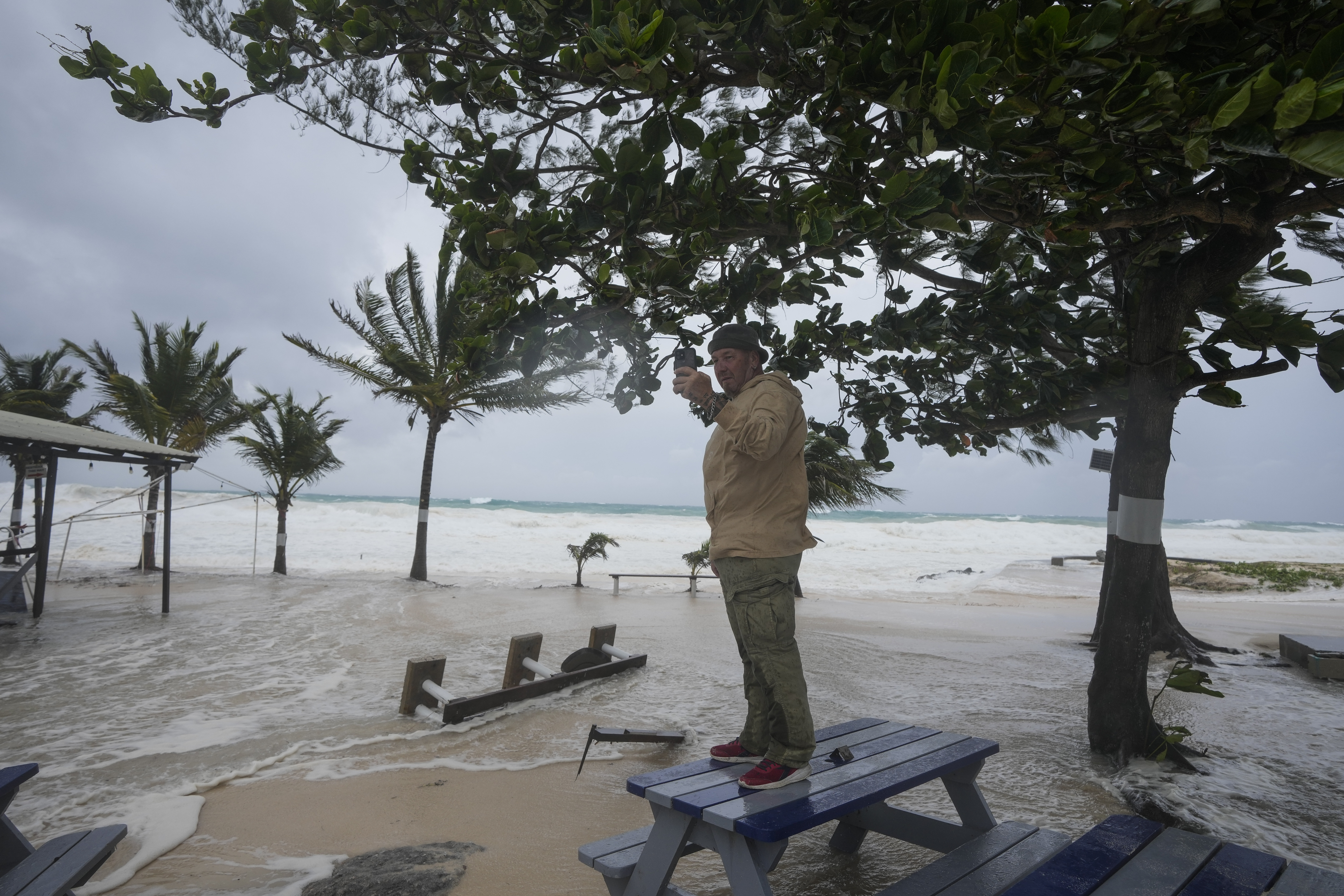 Rick Burn takes photos of damage caused by Hurricane Beryl in Hastings, Barbados, on Monday, July 1, 2024. Photo credit: Ricardo Mazalan, The Associated Press