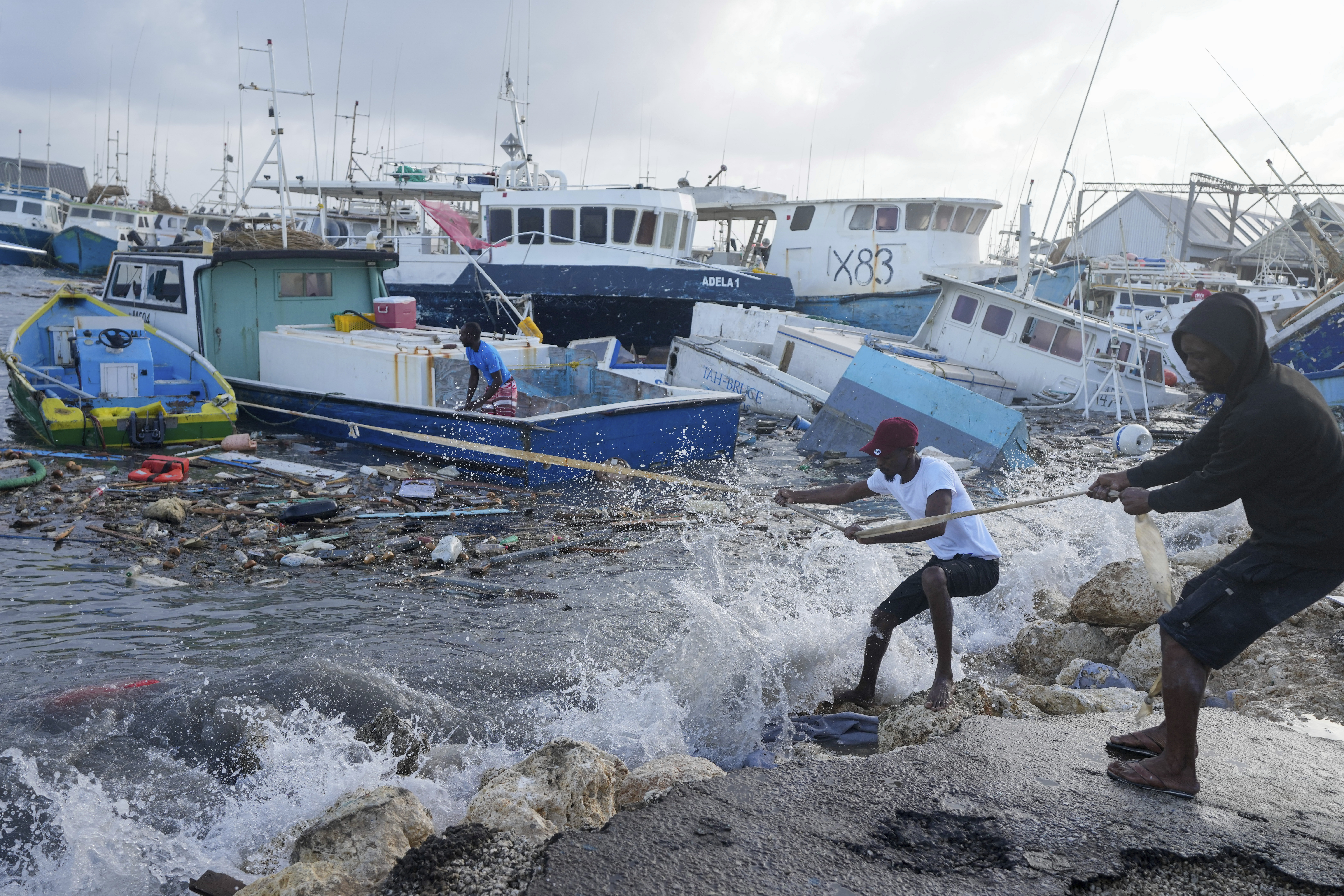 Fishermen pull a boat damaged by Hurricane Beryl back to the dock at the Bridgetown Fisheries in Barbados on Monday, July 1, 2024. Photo credit: Ricardo Mazalan, The Associated Press
