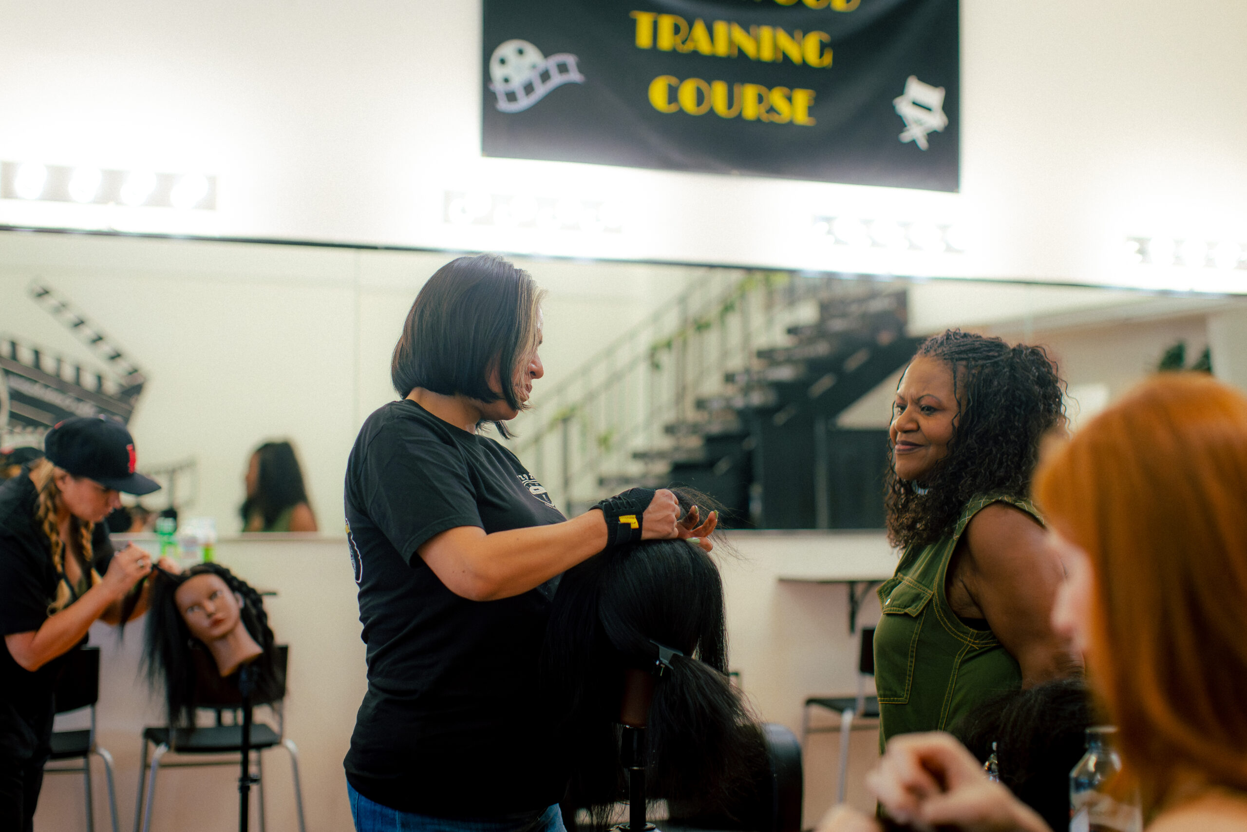 Griselda Govea takes part in "Hands-on Braiding Class From Beginners to Advanced" at Beyond the Combs Academy, Los Angeles, while founder Rhonda O'Neal observes her work on July 6, 2025. Photo credit: Yemi Seyi 