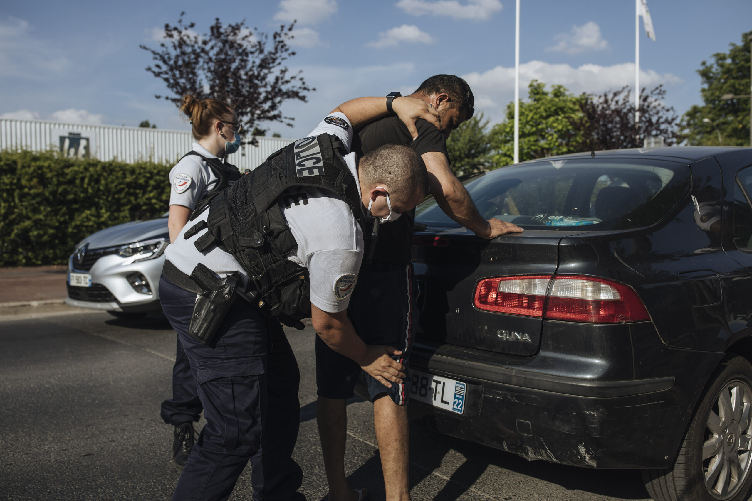 A police officer searches an immigrant in Garges-les-Gonesse, a suburb of Paris, on June, 15, 2021. Photo credit: Lewis Joly, The Associated Press