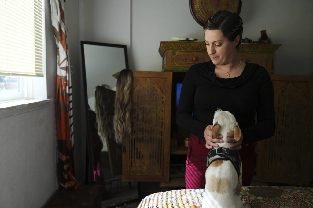 Havalah Hopkins, a single mother who lives in government-subsidized housing with her teenage son, pets her dog, Benny, in her bedroom on Monday, July 14, 2025, in Woodinville, Washington. Photo credit: Lindsey Wasson, The Associated Press
