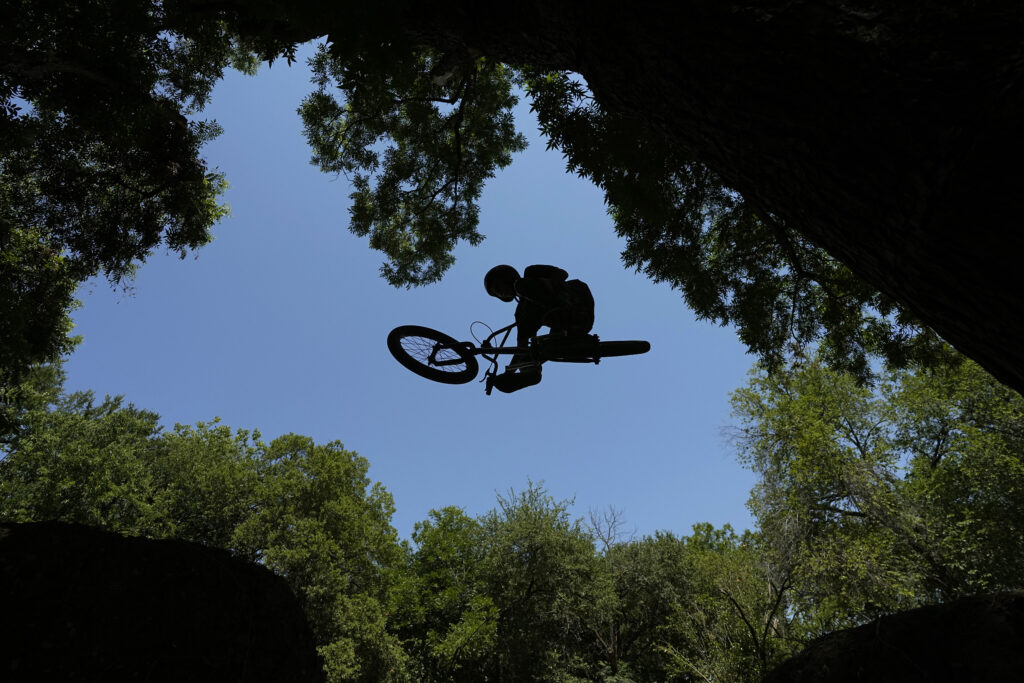 Issac Bowman rides his bike on dirt trails in Austin, Texas, on June 28, 2023. Photo credit: Eric Gay, The Associated Press