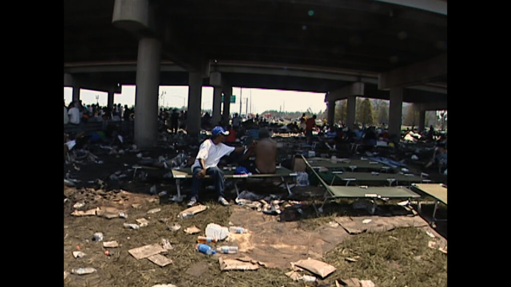 Stranded New Orleans residents gather underneath the interstate following Hurricane Katrina in 2005, as shown in the NatGeo documentary "Hurricane Katrina: Race Against Time." Photo credit: KTVT-TV
