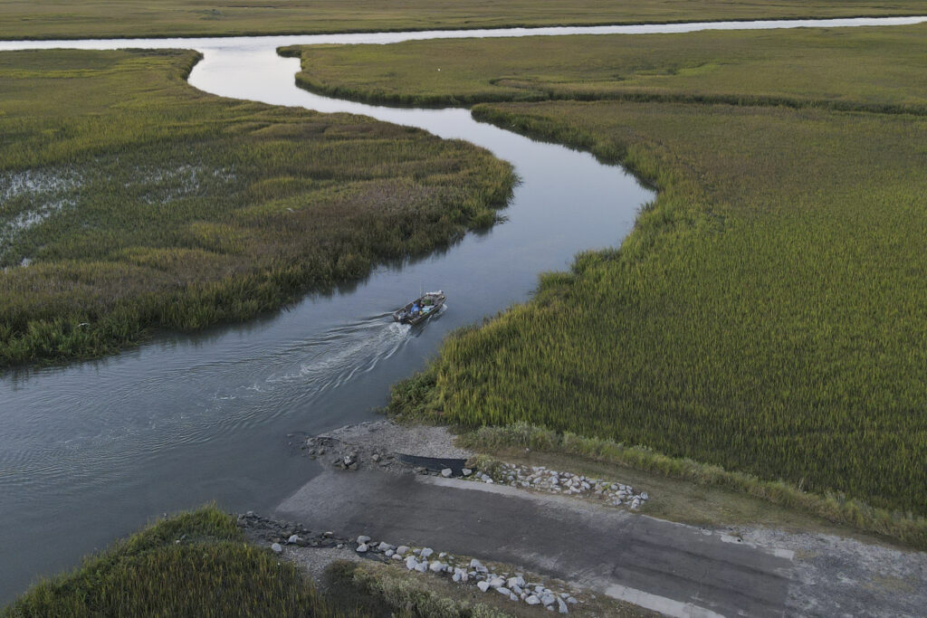 Fishermen set off through marshland waterways on St. Helena Island, South Carolina, on Oct. 31, 2021. Photo credit: Rebecca Blackwell, The Associated Press